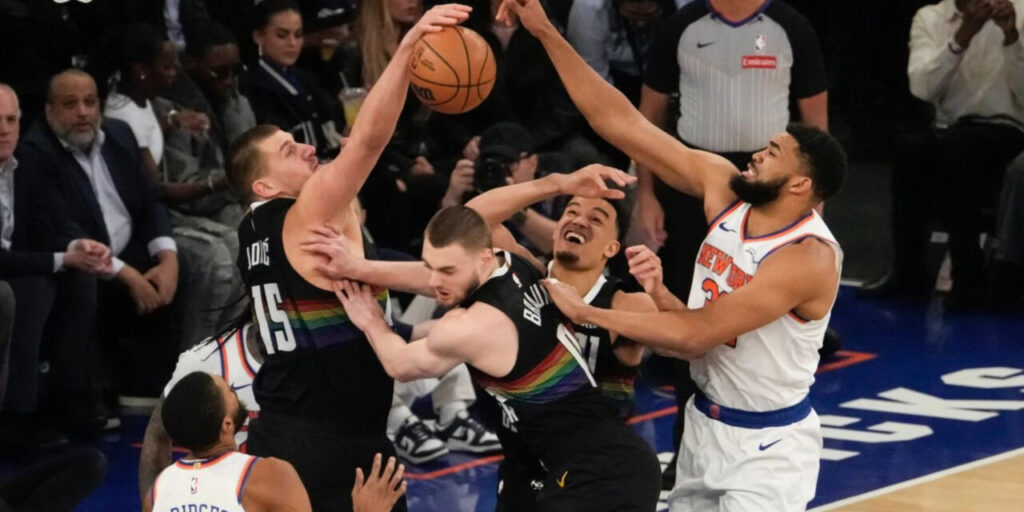 Nikola Jokic and Karl-Anthony Towns jumping for a high ball