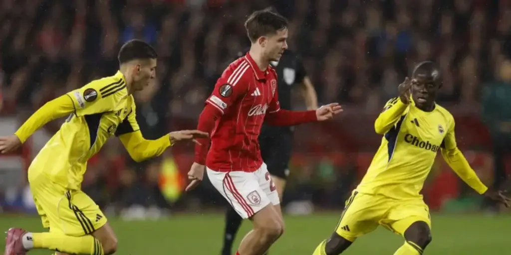 Nottingham Forest player surrounded by 2 Fenerbahce opponents