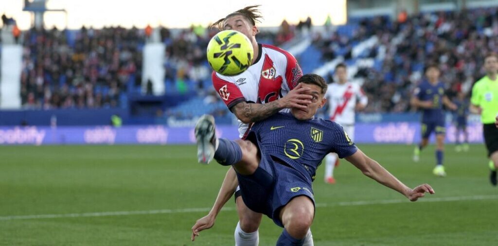 Rayo Vallecano player bringing down an Atletico Madrid opponent