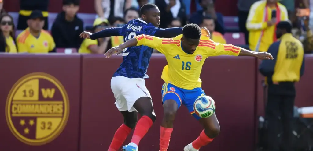 Randal Kolo Muani trying to take the ball from Colombia player