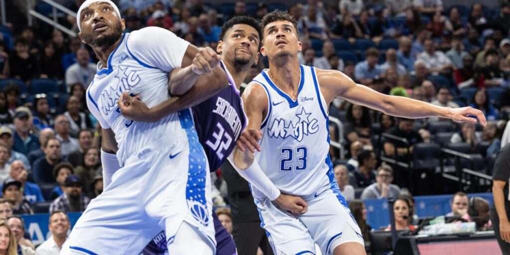 Two Orlando Magic players blocking Sacramento's Maxime Raynaud