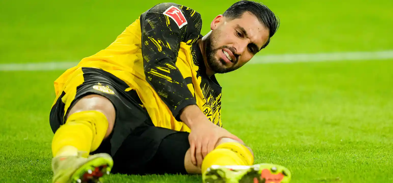 Emre Can holding his left knee in pain