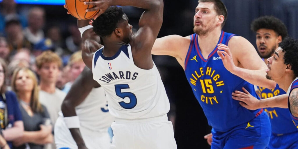 Anthony Edwards protecting the ball from Nikola Jokic