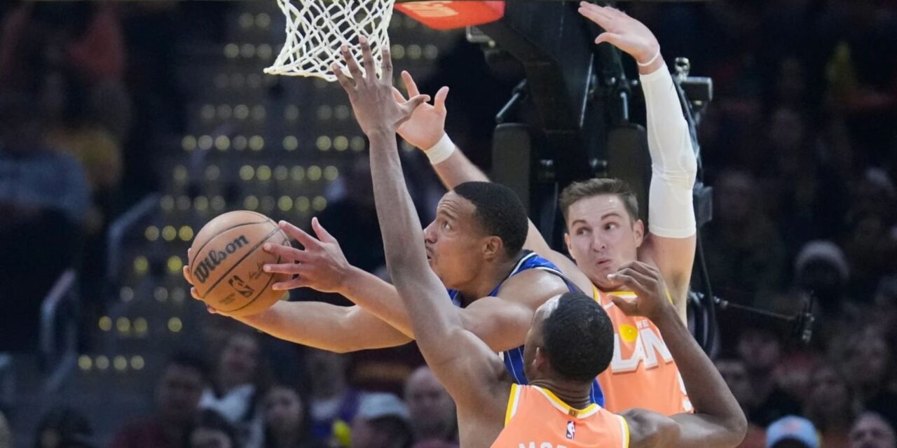Cleveland Cavaliers players trying to stop an Orlando Magic opponent from scoring Orlando Magic