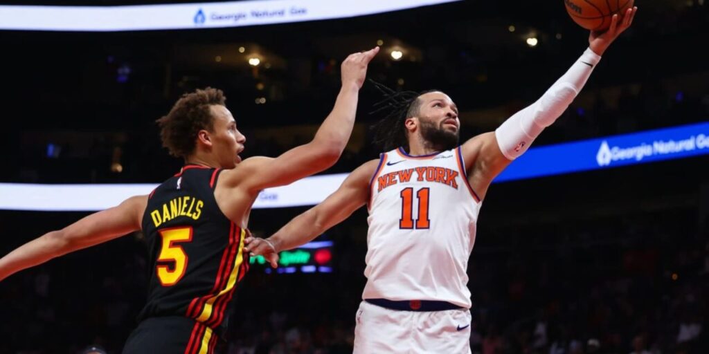 Jalen Brunson lays the ball in Atlanta's basket despite Dyson Daniels defence