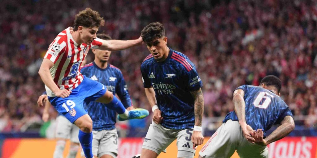 Julian Alvarez surrounded by a couple of Arsenal players