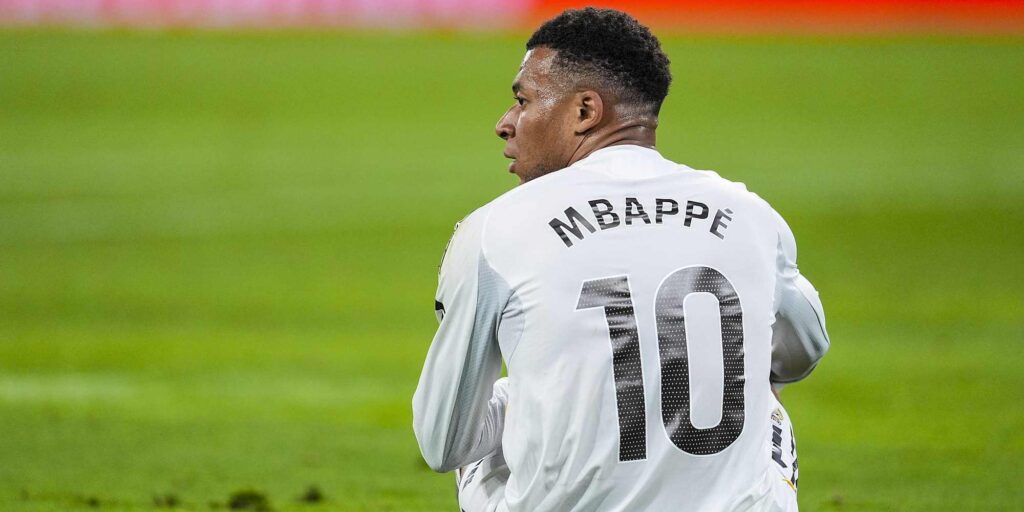 Kylian Mbappe sitting on the ground