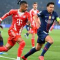 Michael Olise and Marquinhos sprinting for the ball