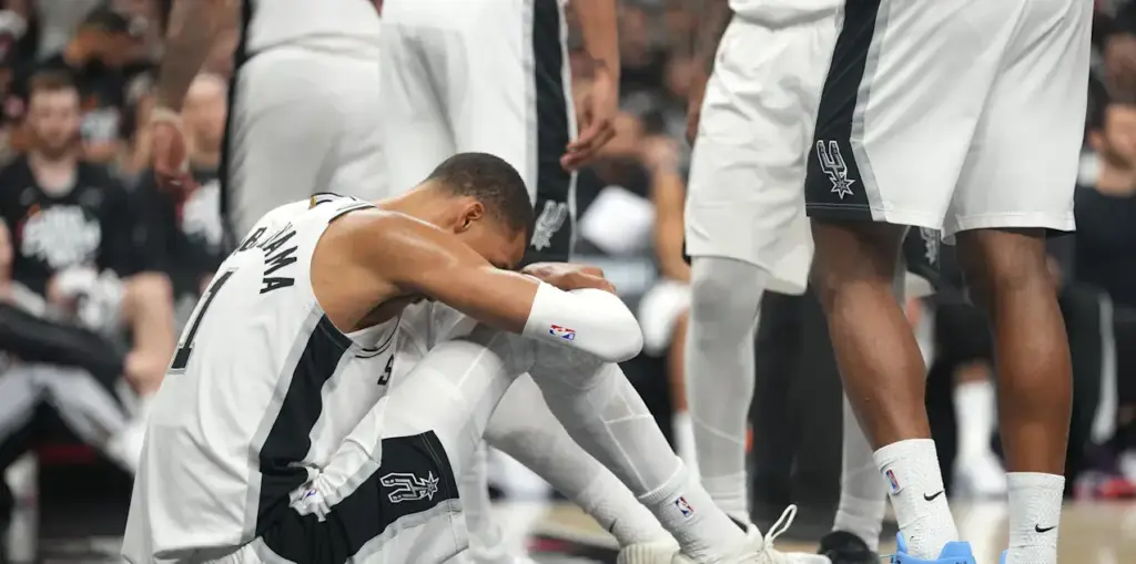 Victor Wembanyama sitting on the court with an injury