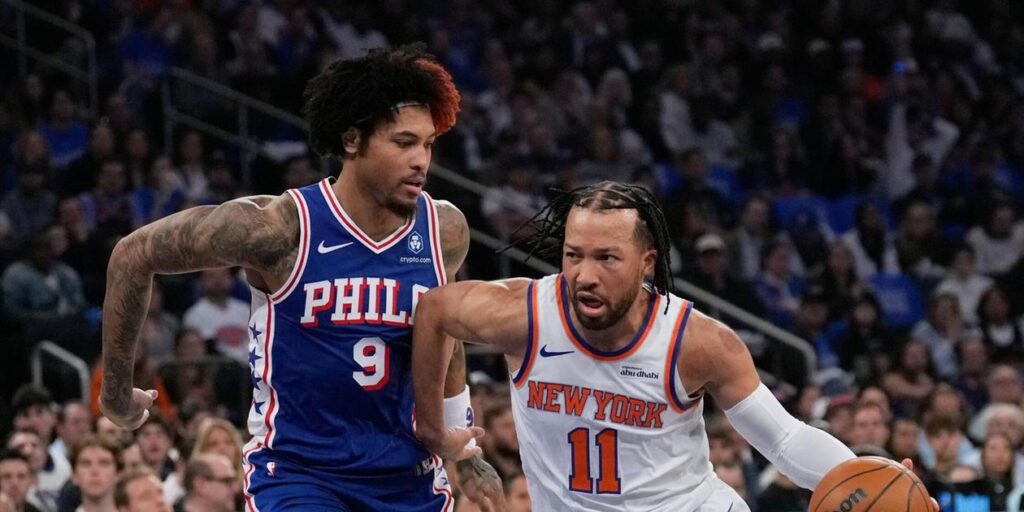 Jalen Brunson dribbling the ball, guarded by Kelly Oubre Jr.