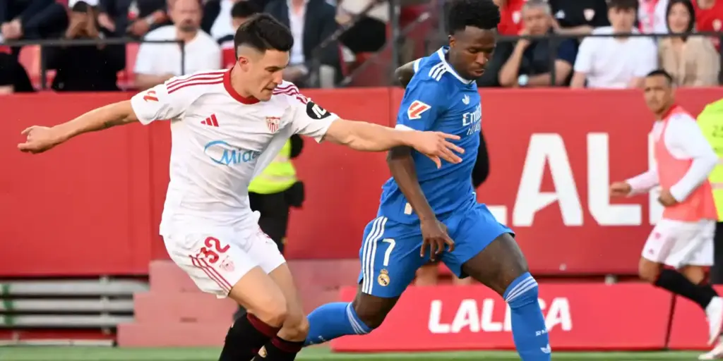 Sevilla player trying to stop Vinicius Junior