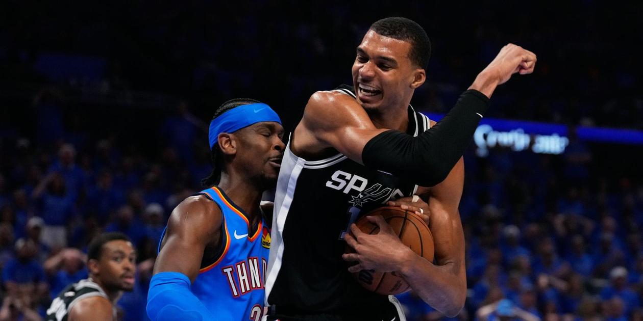 Victor Wembanyama protecting the ball from Shai Gilgeous-Alexander
