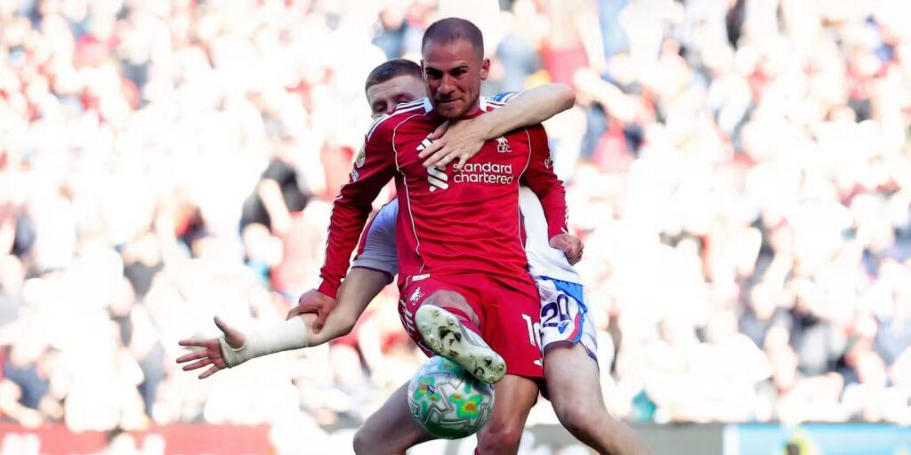 An opponent holding Alexis Mac Allister