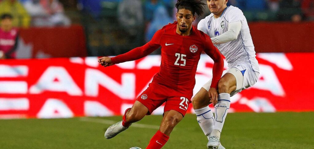 Canada player trying to evade an opponent from Uzbekistan