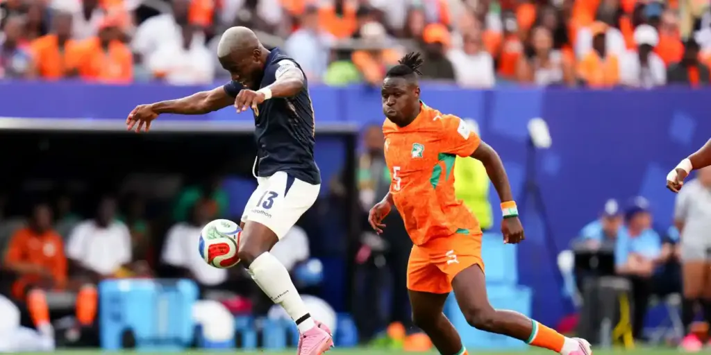 Ecuador player protecting the ball from an Ivory Coast opponent