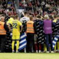 Players and staff surrounding Christian Eriksen who has collased during Denmark's friendly with Ukraine