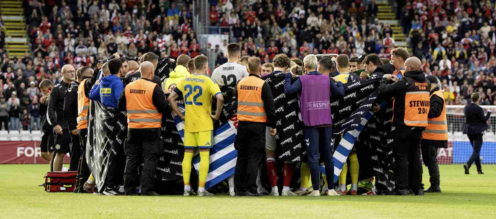 Players and staff surrounding Christian Eriksen who has collased during Denmark's friendly with Ukraine
