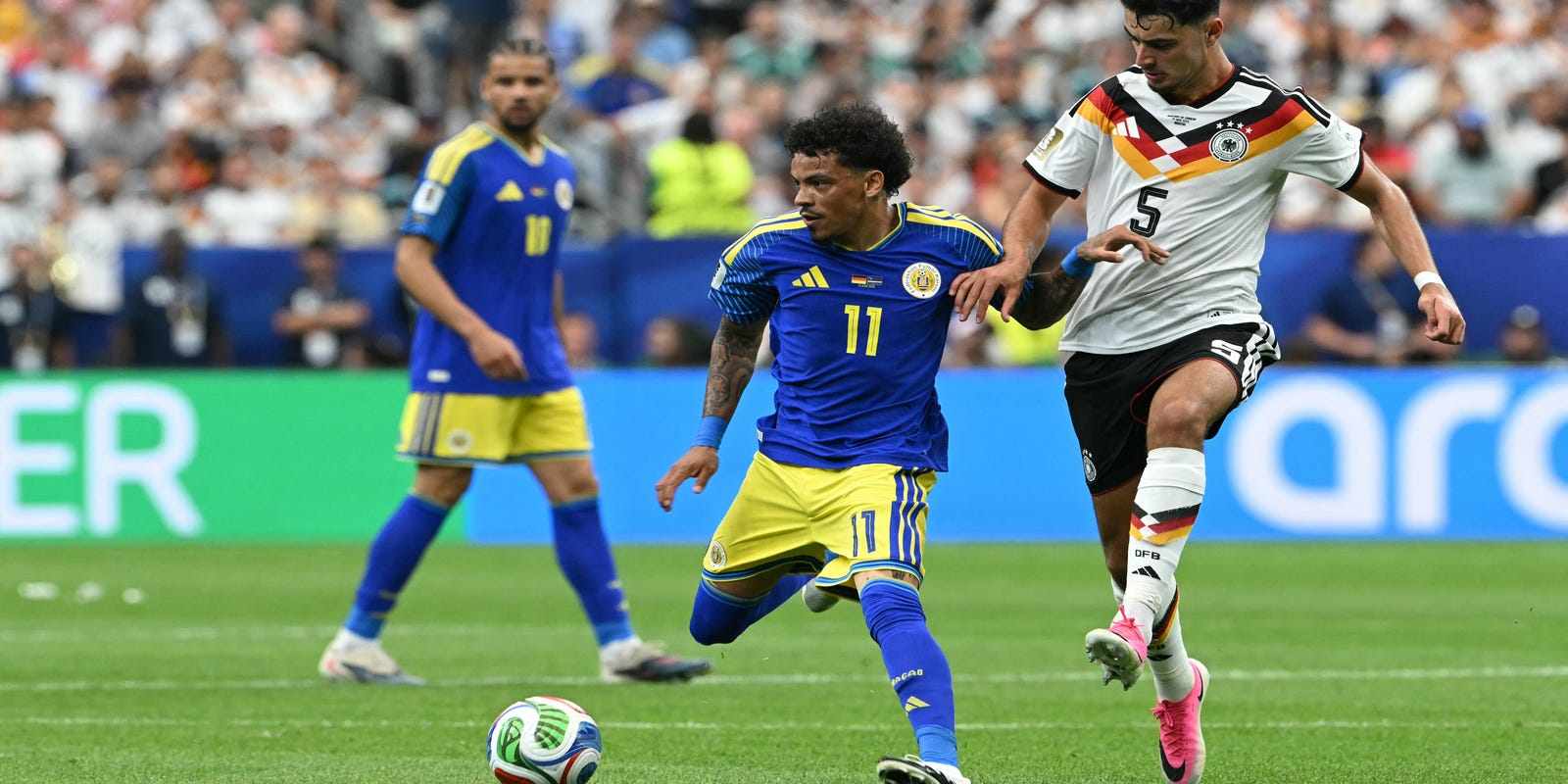 Curacao players guarding the ball from a German opponent