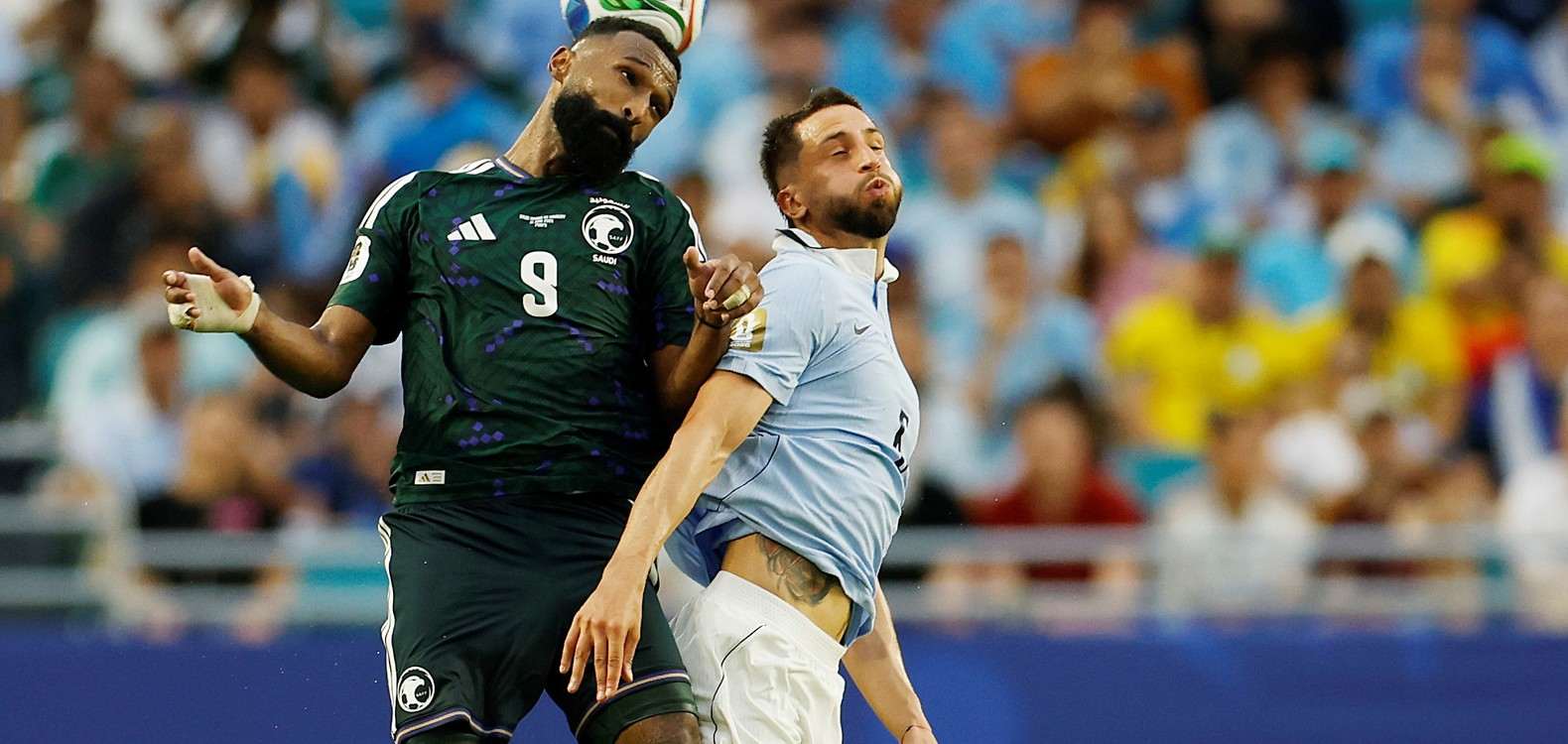 Players from Saudi Arabia and Uruguay jumping for a high ball