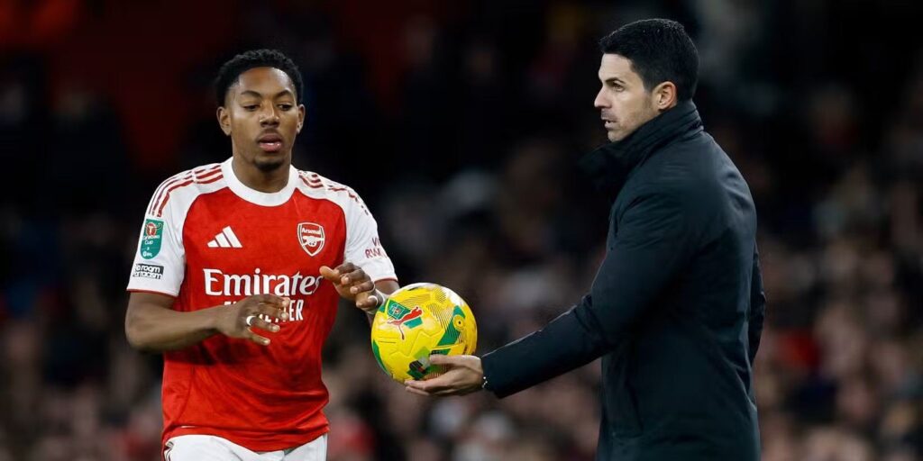 Mikel Arteta handing the ball to Myles Lewis-Skelly