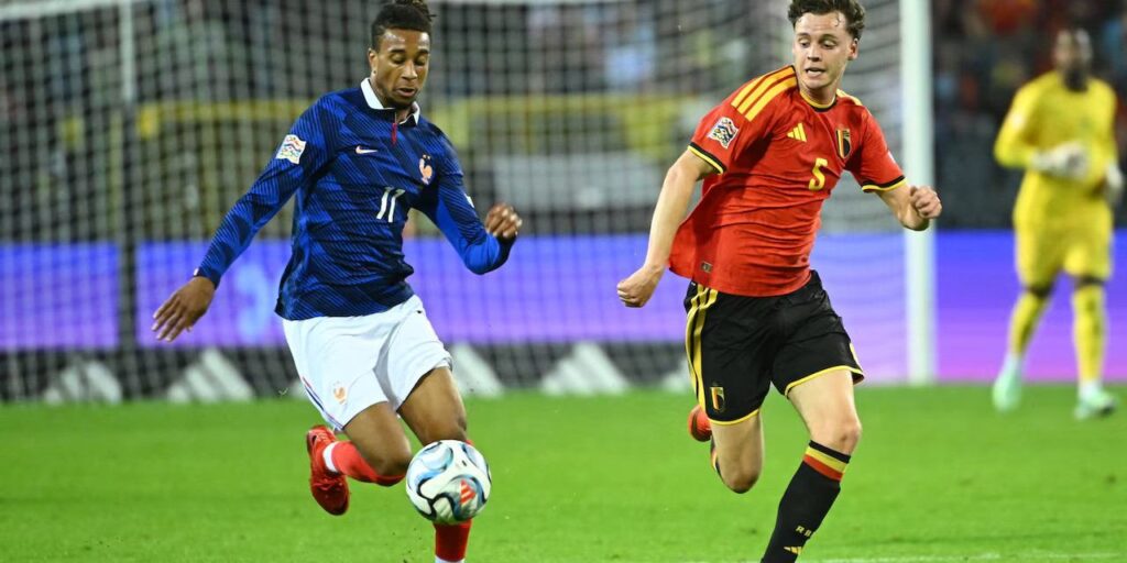 Michael Olise trying to dribble past a Belgium player