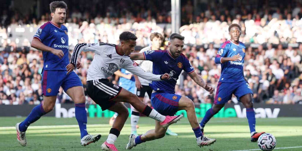 Fulham player shooting toward Manchester United's goal