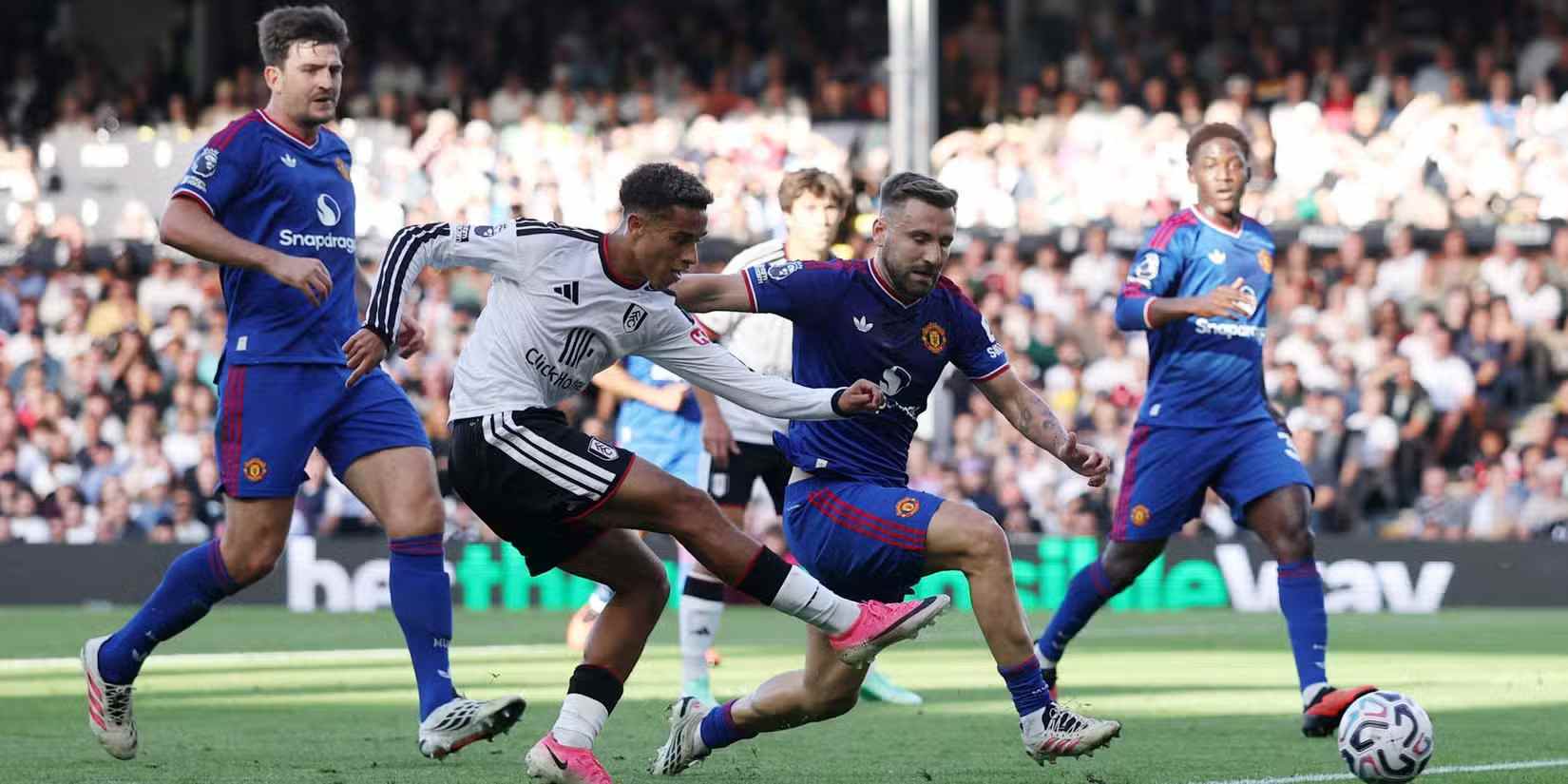 Fulham player shooting toward Manchester United's goal
