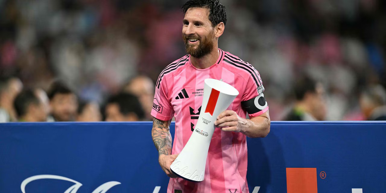 Lionel Messi posing with another cup