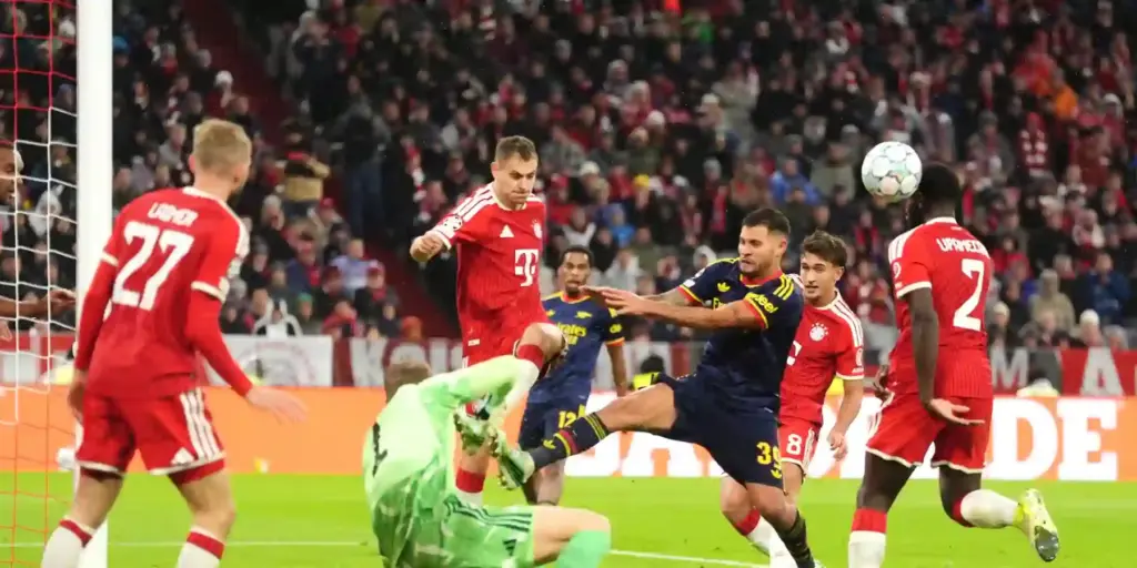 Bayern Munich and Arsenal players in a battle for a high ball