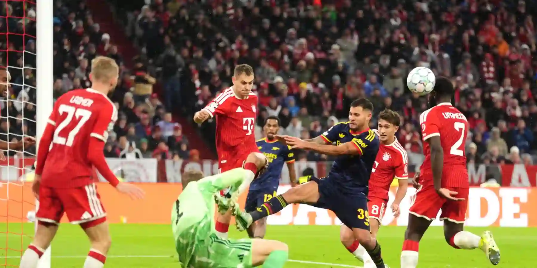 Bayern Munich and Arsenal players in a battle for a high ball