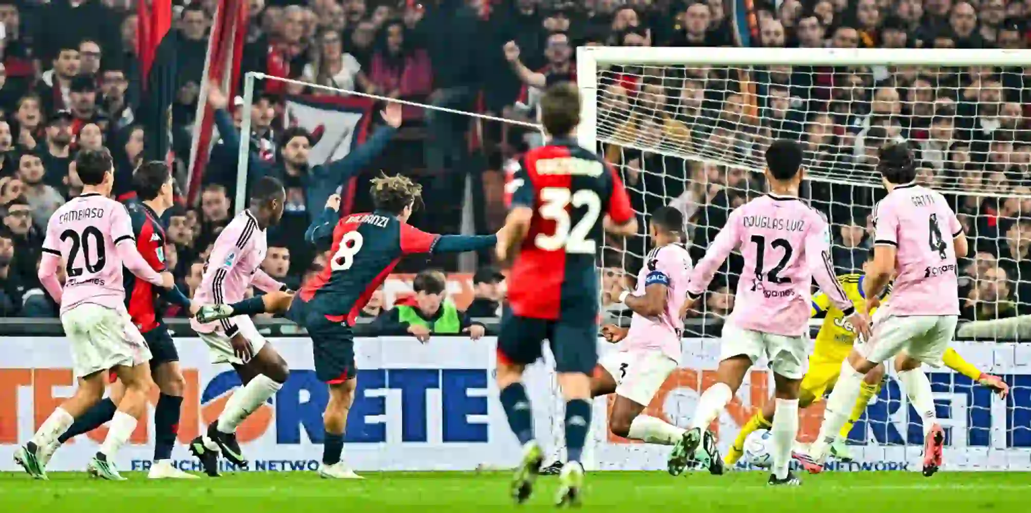 Genoa player shooting toward Juventus' goal
