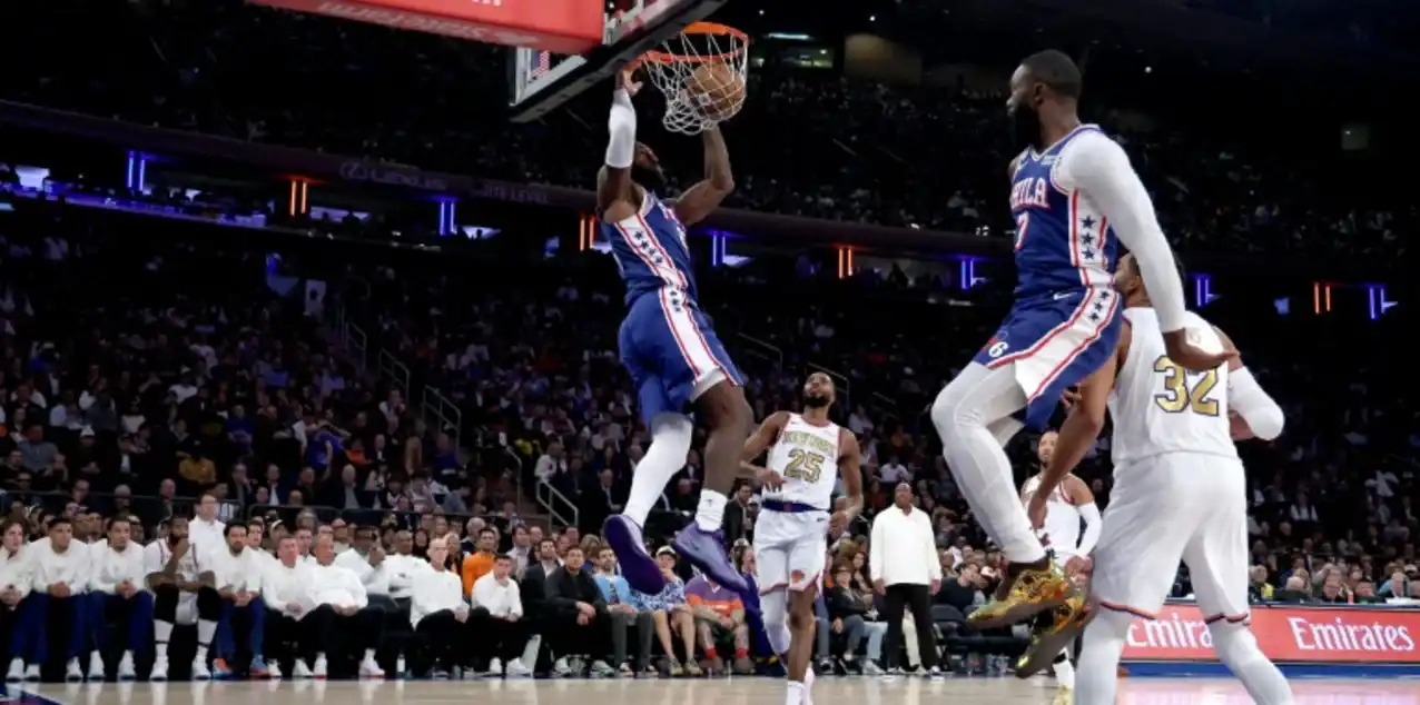 Philadelphia 76ers player dunking the ball in New York Knicks' basket