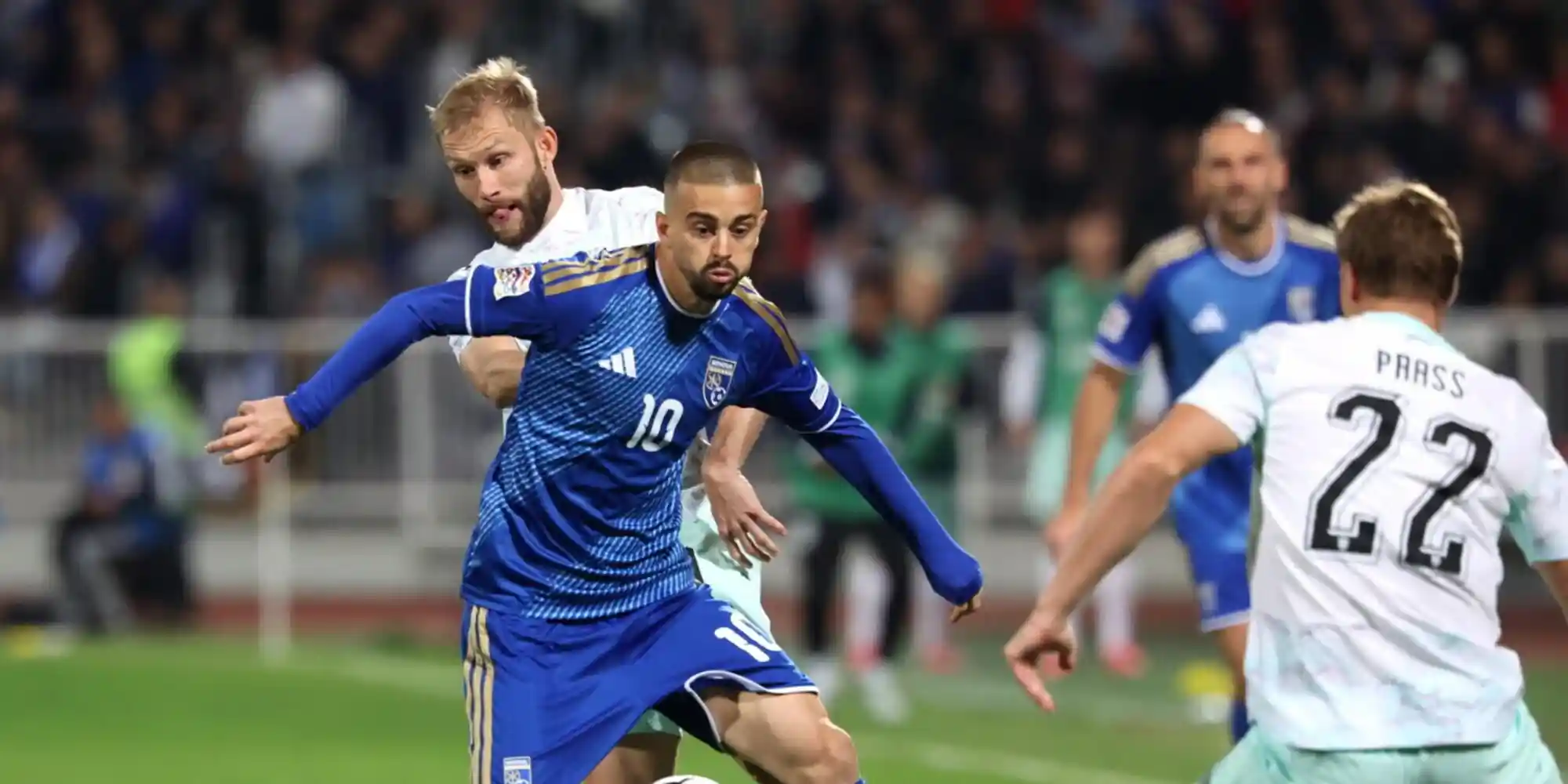 Kosovo player trying to evade from 2 Austria opponents