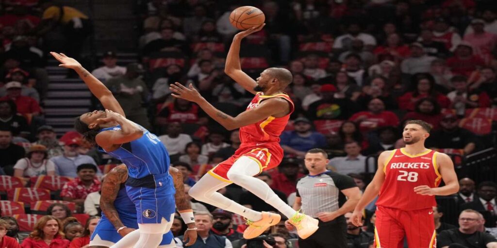 Kevin Durant shoots the ball guarded by a Dallas Mavericks player