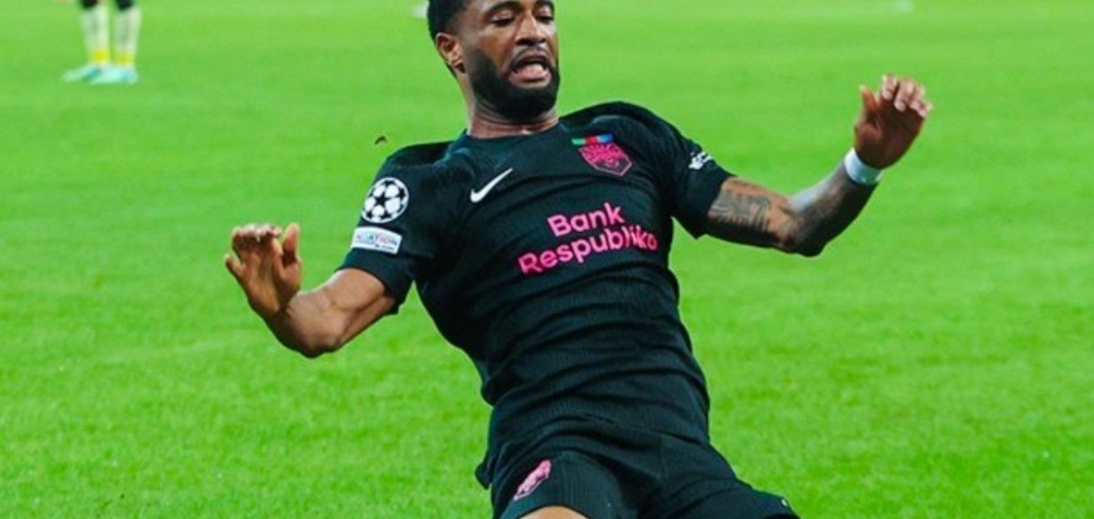 Joy-Lance Mickels sliding on his knees after scoring for Sabah against Slavia Prague