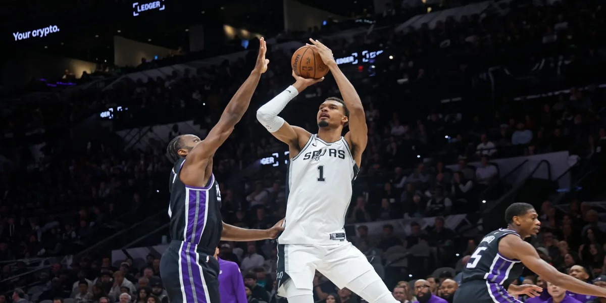 Victor Wembanyama shooting over Sacramento Kings player