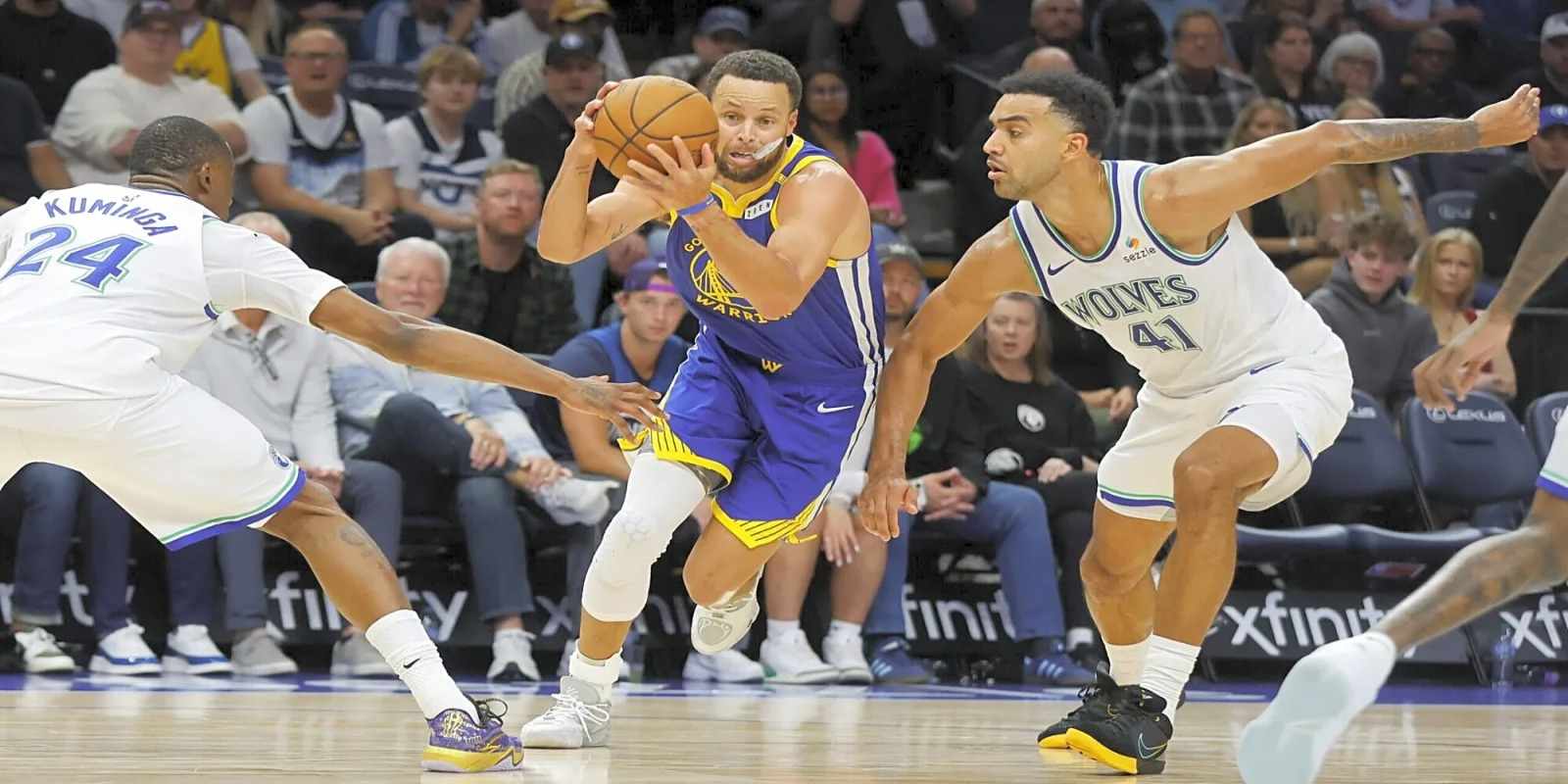 Steph Curry dribbling the ball between two Minnesota Timberwolves players
